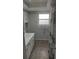 Neutral bathroom featuring a single sink vanity, tiled floor, and a window providing natural light at 1001 Sandlewood Dr, Venice, FL 34293