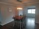 Elegant dining room featuring stylish light fixture, hardwood floors, and a wood dining table at 1001 Sandlewood Dr, Venice, FL 34293