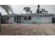 Charming one-story home featuring a light blue exterior, pink shutters and a circular driveway at 1001 Sandlewood Dr, Venice, FL 34293