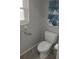 White toilet with decorative wall art and a window providing natural light at 1001 Sandlewood Dr, Venice, FL 34293