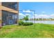 The backyard features lush green grass and access to a screened patio with lake view at 10808 Tarflower Dr # 102, Venice, FL 34293