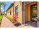 Screened front door opens to brick paver sidewalk and landscaped beds at 10808 Tarflower Dr # 102, Venice, FL 34293