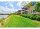 The exterior showcases multiple screened in patios, a lakeside view, and lawn at 10808 Tarflower Dr # 102, Venice, FL 34293