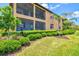 Exterior view of the home showcasing the screened patios and lush landscaping at 10808 Tarflower Dr # 102, Venice, FL 34293