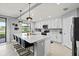 Bright kitchen featuring a large island with bar stools, white cabinets, and modern appliances at 10808 Tarflower Dr # 102, Venice, FL 34293