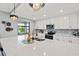 Bright kitchen featuring a large island, white cabinetry, and modern finishes at 10808 Tarflower Dr # 102, Venice, FL 34293