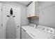 Laundry room featuring a washer and dryer, ironing board, white cabinets and gray walls at 10808 Tarflower Dr # 102, Venice, FL 34293
