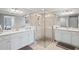 Bright main bathroom with double-sink vanity, a walk-in glass shower, and tile floors at 10808 Tarflower Dr # 102, Venice, FL 34293