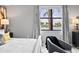 Main bedroom sitting area has large window with beautiful view, gray walls and modern lamp at 10808 Tarflower Dr # 102, Venice, FL 34293