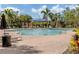 Large community pool with lounge chairs and umbrellas surrounded by lush landscaping at 11228 Fieldstone Dr, Palmetto, FL 34221