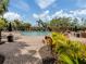 A winding community pool is surrounded by tropical vegetation and brick pavers at 11228 Fieldstone Dr, Palmetto, FL 34221