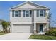 Charming two-story home featuring blue shutters, manicured lawn, and an attached two car garage at 11228 Fieldstone Dr, Palmetto, FL 34221