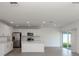 Bright, open-concept living area features white cabinets, stainless steel appliances, tile flooring, and natural light at 11228 Fieldstone Dr, Palmetto, FL 34221