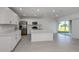 Bright, open-concept living area features white cabinets, stainless steel appliances, tile flooring, and natural light at 11228 Fieldstone Dr, Palmetto, FL 34221
