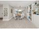 Dining area boasts light from a bay window, modern furniture, and custom built-in shelving for storage and display at 1234 Paradise Way, Venice, FL 34285