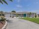Charming single-story home boasts a well-manicured lawn, elegant landscaping, and a stylish turquoise double-door entrance at 1234 Paradise Way, Venice, FL 34285