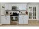Bright kitchen with stainless steel oven, microwave, white cabinetry, and tile floors at 1234 Paradise Way, Venice, FL 34285