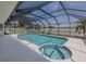 Spacious screened in swimming pool and jacuzzi with surrounding white concrete at 1234 Paradise Way, Venice, FL 34285
