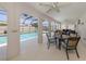 Inviting covered pool patio area with ceiling fans and a dining set enhances outdoor living at 1234 Paradise Way, Venice, FL 34285