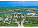 Aerial view features a gated community with a lake, tennis courts, pool, and manicured landscaping at 12728 Richezza Dr, Venice, FL 34293