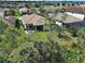 Aerial view of a home with a screened-in lanai surrounded by trees and lush landscaping at 12728 Richezza Dr, Venice, FL 34293