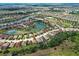 Aerial view of a community with numerous homes, ponds, and lush greenery at 12728 Richezza Dr, Venice, FL 34293