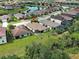 Aerial view of the home featuring a screened-in lanai, tile roof, and landscaping at 12728 Richezza Dr, Venice, FL 34293