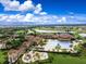 An aerial view showcases a beautiful community with a pool, clubhouse, playground, and lush landscaping at 12728 Richezza Dr, Venice, FL 34293