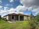 Well-manicured backyard featuring a screened lanai, lush green lawn, and neatly trimmed landscaping at 12728 Richezza Dr, Venice, FL 34293