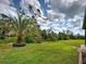Expansive backyard with lush green lawn, mature trees, and landscaped features at 12728 Richezza Dr, Venice, FL 34293