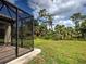 A screened lanai offers an inviting space overlooking the home's well-manicured backyard at 12728 Richezza Dr, Venice, FL 34293