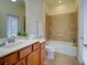 Bright bathroom features tile floors, bathtub with tiled walls, and a sink at 12728 Richezza Dr, Venice, FL 34293