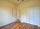 Bedroom with wood-look flooring, closet, and door to another room at 12728 Richezza Dr, Venice, FL 34293