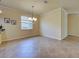 Dining room with tile floors, neutral paint, chandelier, and a large window at 12728 Richezza Dr, Venice, FL 34293