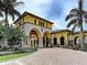 Elegant community entrance with stone accents, lush landscaping, and stately architecture at 12728 Richezza Dr, Venice, FL 34293