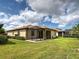 Exterior view of the home showing a screened in patio and lush green grass at 12728 Richezza Dr, Venice, FL 34293