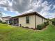 Exterior view of a well-maintained home, featuring a screened-in patio and manicured lawn at 12728 Richezza Dr, Venice, FL 34293