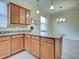 An open kitchen with light wood cabinets, granite countertops, and tile backsplash at 12728 Richezza Dr, Venice, FL 34293