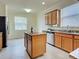 A kitchen island and stainless steel appliances against wood cabinets at 12728 Richezza Dr, Venice, FL 34293