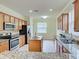 Kitchen with stainless steel appliances, wood cabinets, granite countertops, and tile floors at 12728 Richezza Dr, Venice, FL 34293