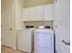Well-equipped laundry room with washer, dryer, and upper cabinets for storage at 12728 Richezza Dr, Venice, FL 34293