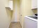 Laundry room with overhead cabinets and tiled flooring at 12728 Richezza Dr, Venice, FL 34293