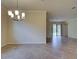 Spacious living room with neutral paint, trim, and tile flooring leading to sliding glass doors at 12728 Richezza Dr, Venice, FL 34293