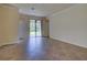 Open living room with tile flooring and sliding glass doors to the backyard at 12728 Richezza Dr, Venice, FL 34293