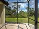 Covered patio features travertine flooring with tranquil views of the backyard's lush landscaping at 12728 Richezza Dr, Venice, FL 34293