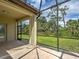A cozy covered patio showcasing tile floors and a serene view of the surrounding greenery at 12728 Richezza Dr, Venice, FL 34293