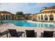 Community pool with ample seating surrounded by lush landscaping and elegant architecture at 12728 Richezza Dr, Venice, FL 34293