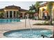 Relaxing community pool area with a spa and comfortable lounge chairs, surrounded by mature landscaping at 12728 Richezza Dr, Venice, FL 34293