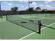 A pristine tennis court with a net and clearly marked lines, perfect for a game or practice session at 12728 Richezza Dr, Venice, FL 34293