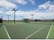 A view of a tennis court area with multiple, well-maintained courts and lighting for evening play at 12728 Richezza Dr, Venice, FL 34293